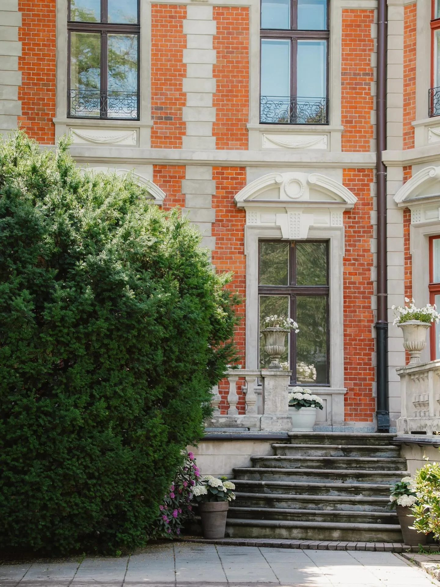 The facade of Konstanty Zamoyski Palace behind the hedge, seen from the ÉTÉ garden